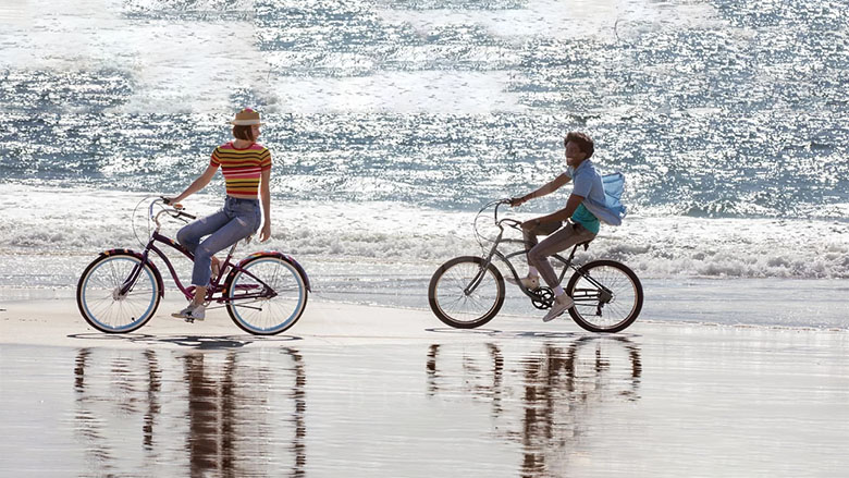 زوج در حال دوچرخه سواری لب ساحل