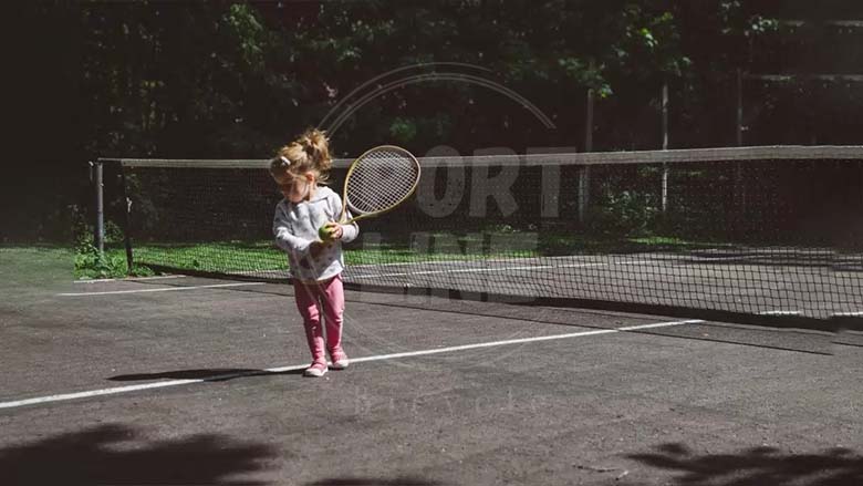 دختر بچه در حال تنیس بازی کردن