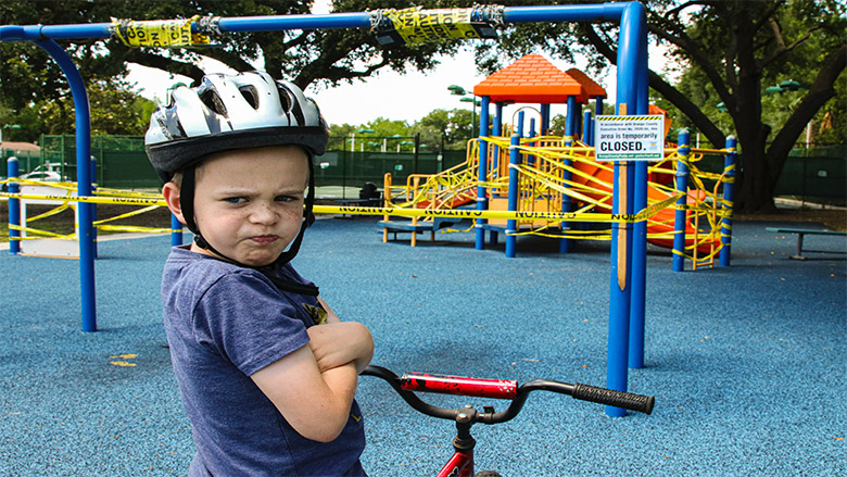 کودک اخمو روی دوچرخه در پارک