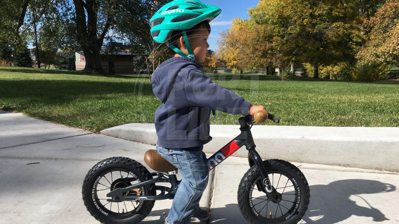 پسر بچه کودک در حال سواری روی دوچرخه کوچک
