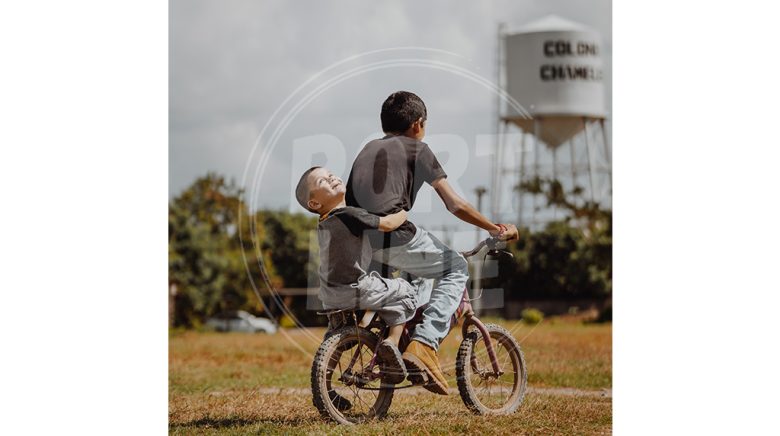 دو کودک شاد در حال دوچرخه سواری