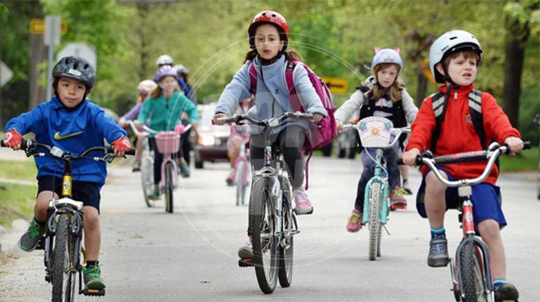 چندین بچه مدرسه ای در حال دوچرخه سواری
